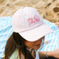 casquette rose portée sur la plage dans les landes - l'atelier des dames x broders cap