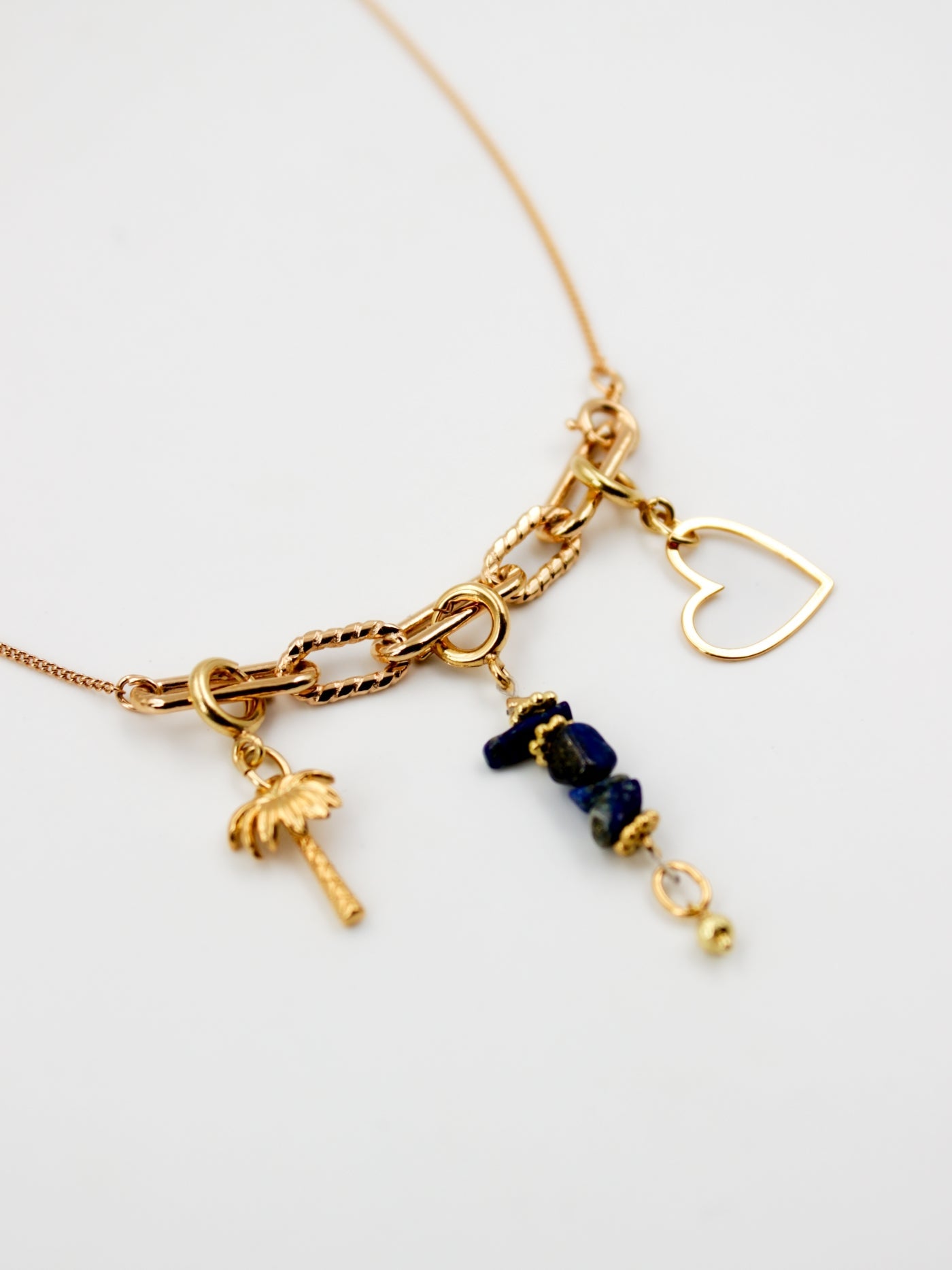 Composition de charms sur le collier fin doré avec 3 anneaux de la gamme GRIGRI - L'Atelier des dames